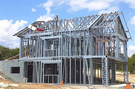 metal framework around a house being renovated|metal framing for residential windows.